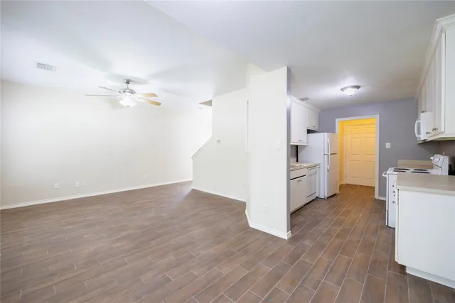 a view of a kitchen with a sink stove cabinets and empty room