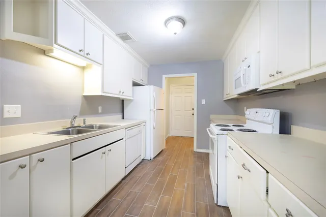 a kitchen with a sink a stove and cabinets