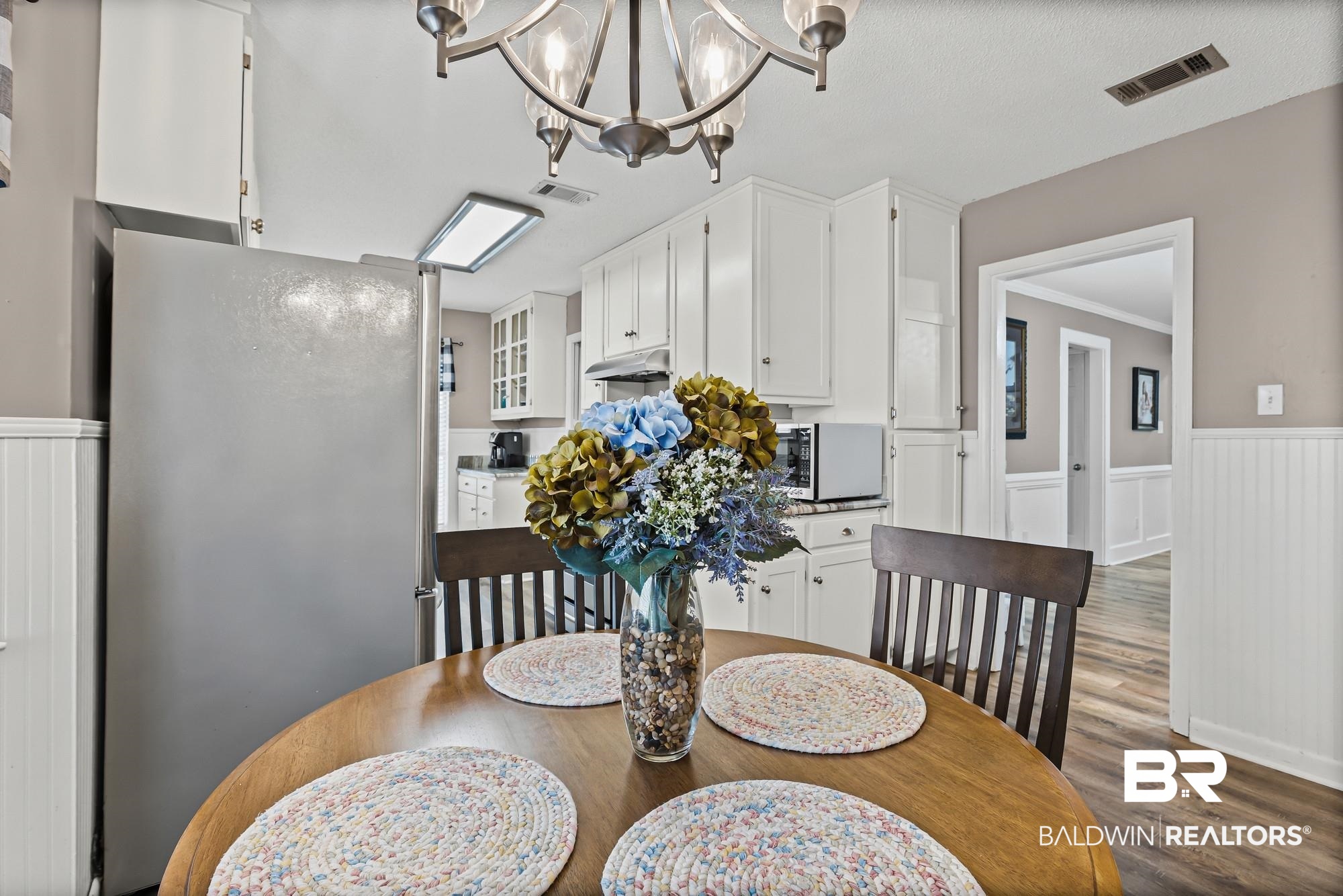 6609 Blakeley Court Mobile, AL 36695 - Photo 8 of 28 Dining space featuring a wainscoted wall, a decorative wall, dark wood-style floors, hanging lights, and ornamental molding