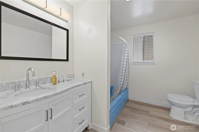 a bathroom with a granite countertop sink toilet and mirror