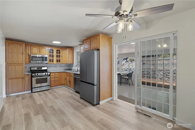 a kitchen with stainless steel appliances kitchen island granite countertop a refrigerator and a stove top oven