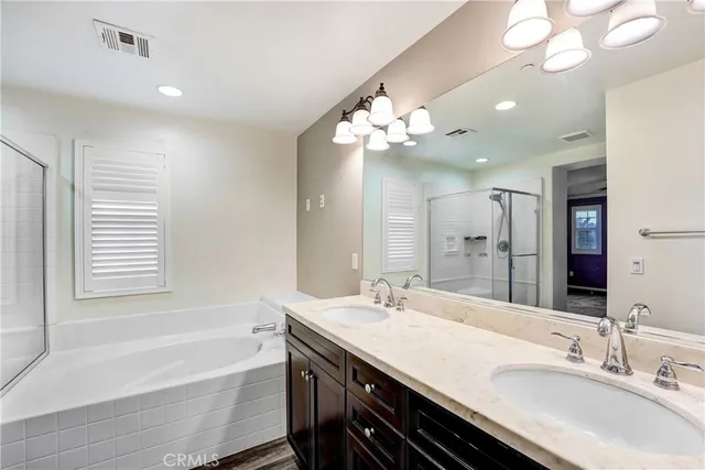 a spacious bathroom with a granite countertop sink a bathtub and a mirror