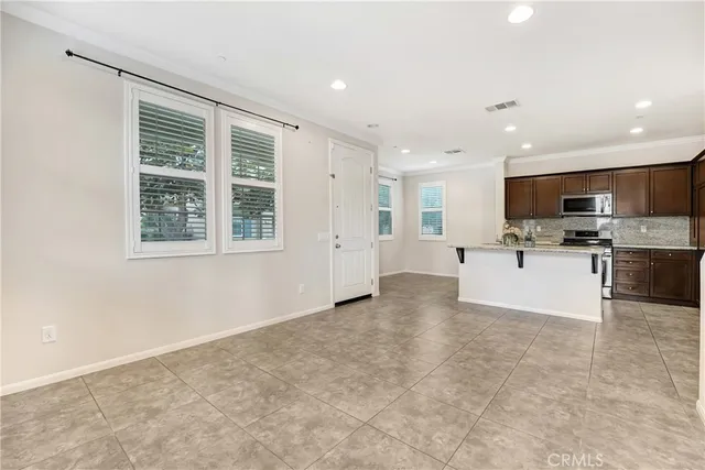 a view of kitchen with stainless steel appliances refrigerator oven microwave and cabinets