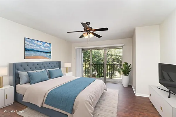 a bedroom with a balcony a bed and a flat screen tv