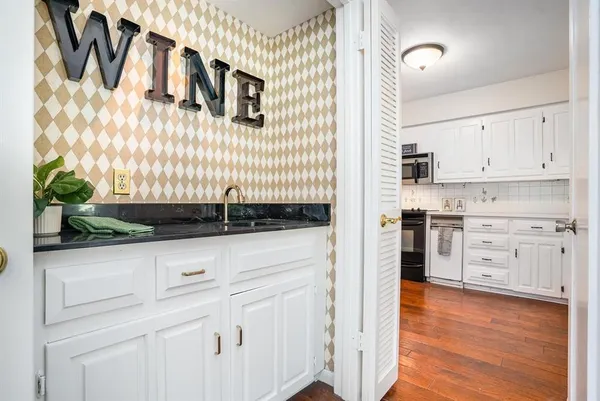 a kitchen with granite countertop white cabinets and white appliances