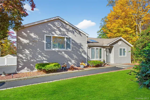 a front view of a house with a yard and potted plants