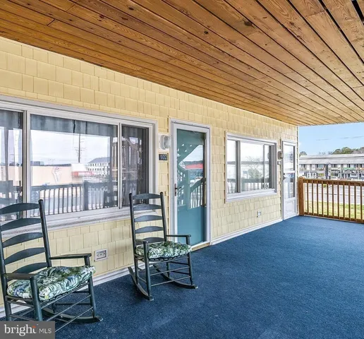 a living room with stainless steel appliances furniture and a kitchen view