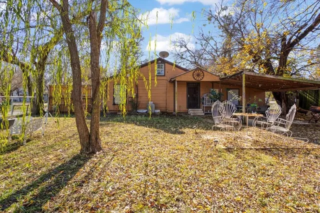 a backyard of a house with table and chairs