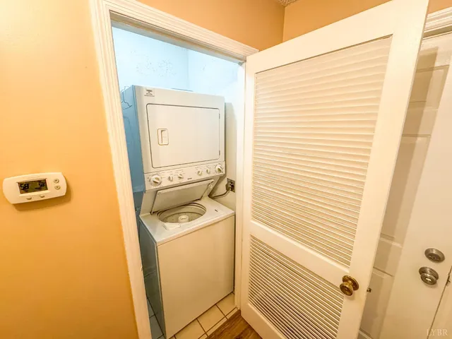 an empty room with wooden floor fireplace and windows