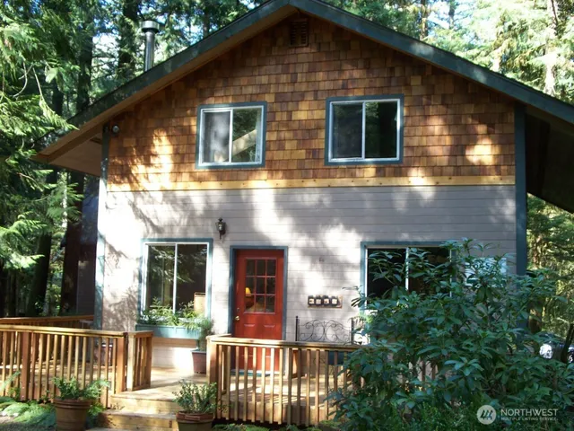 a front view of a house with plants and trees