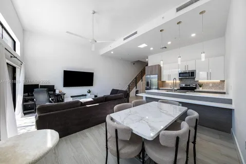 a living room with furniture a flat screen tv and kitchen view
