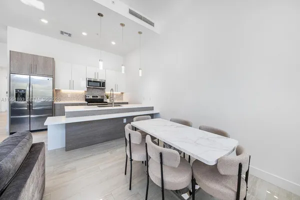 a kitchen with a table chairs microwave and cabinets