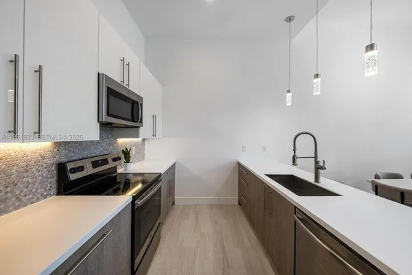 a kitchen with a sink a stove and microwave