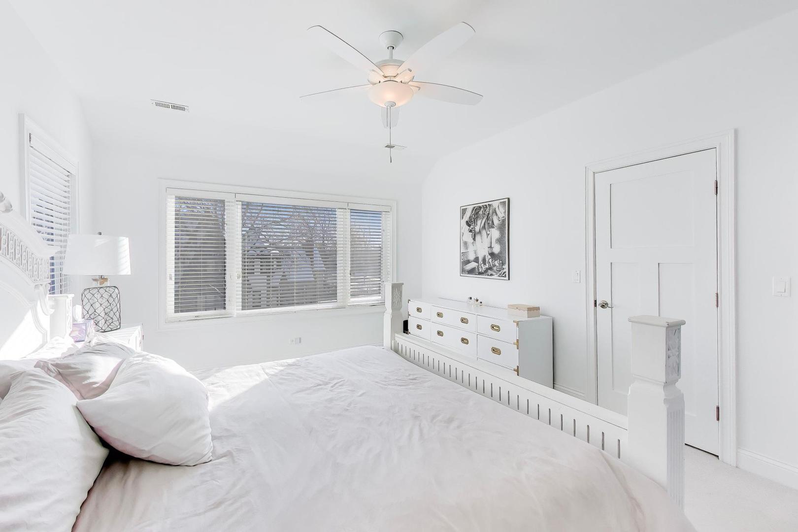 229 North Myrtle Avenue Elmhurst, IL 60126 - Photo 21 of 43 a large white bed sitting in a bedroom next to a window with a chandelier