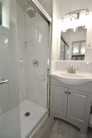 a bathroom with a sink shower and a mirror