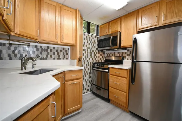 a kitchen with stainless steel appliances granite countertop a refrigerator stove and sink