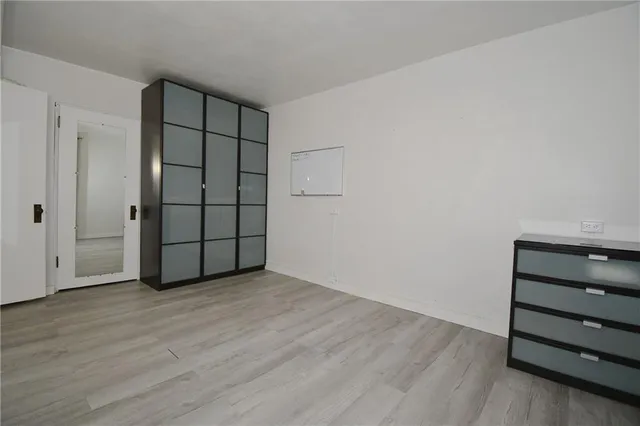 an empty room with wooden floor and closet