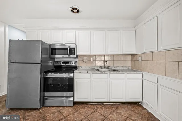 a kitchen with stainless steel appliances granite countertop a refrigerator sink and stove