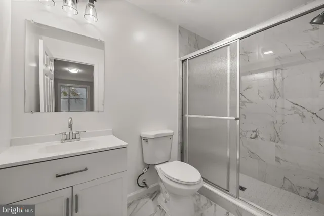 a bathroom with a sink mirror vanity and toilet