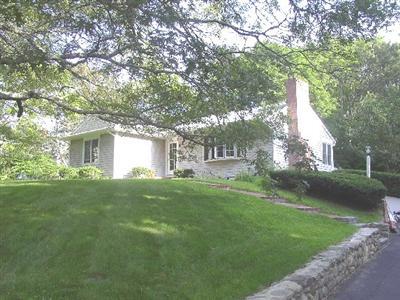 a view of a house with a yard and a large tree