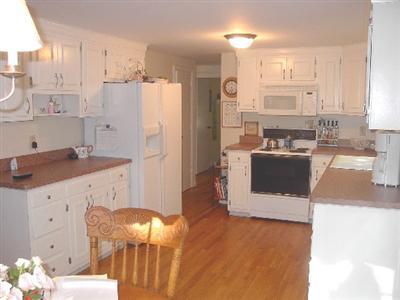 Undisclosed Address Centerville, MA 02632 - Photo 4 of 5 a kitchen with granite countertop a refrigerator a sink a stove and white cabinets