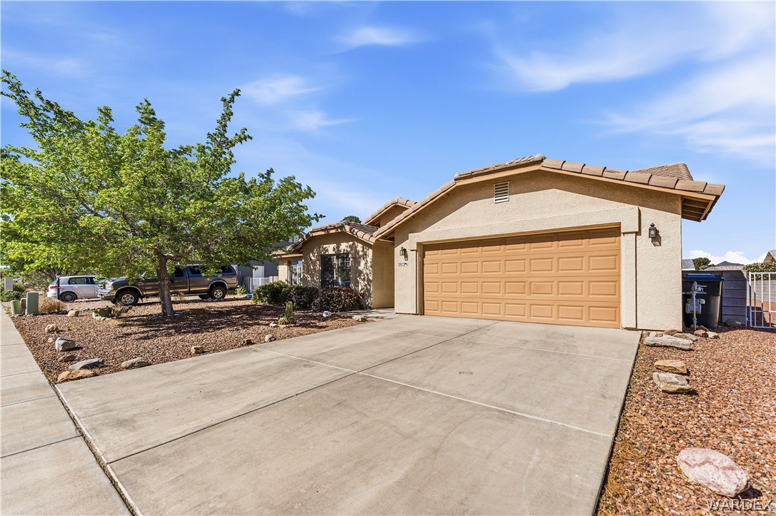 3973 Prairie View Drive Kingman, AZ 86409 - Photo 2 of 34 The property features a stucco exterior, a two-car garage with a brown door, and a concrete driveway