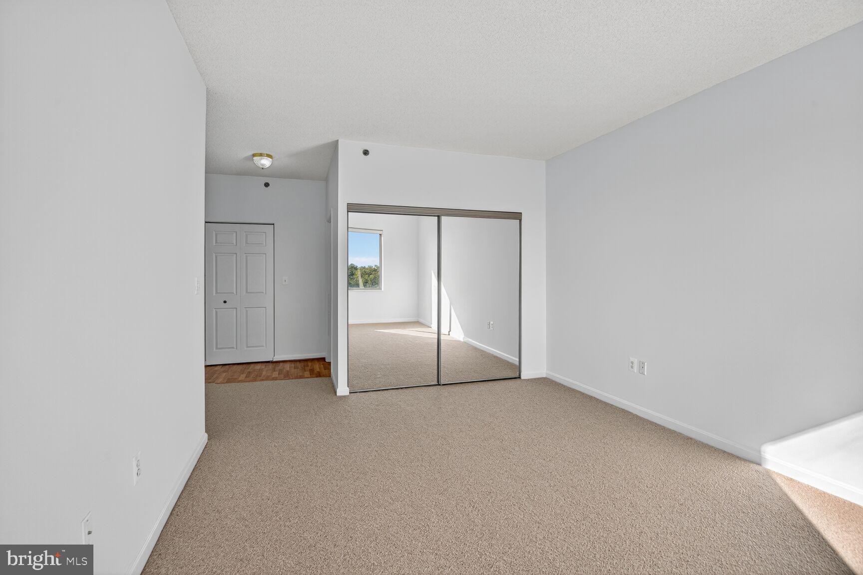 3200 North Leisure World Boulevard, Unit 918 Silver Spring, MD 20906 - Photo 11 of 22 an empty room with sliding glass door and closet