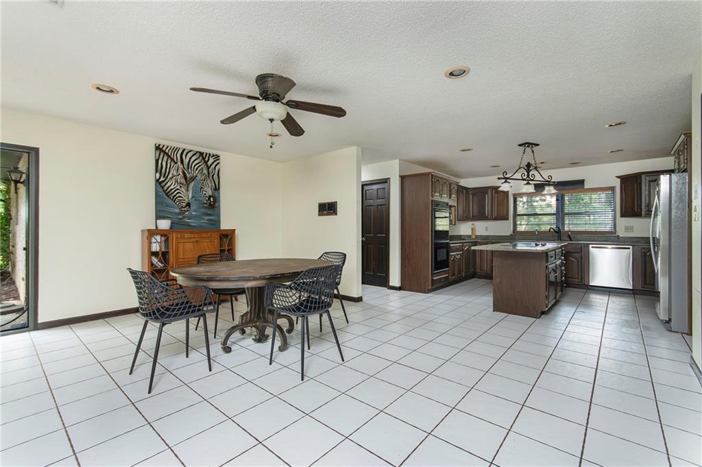 2301 Brooks Road Southeast Dacula, GA 30019 - Photo 27 of 63 a kitchen with stainless steel appliances kitchen island granite countertop a table chairs and a refrigerator