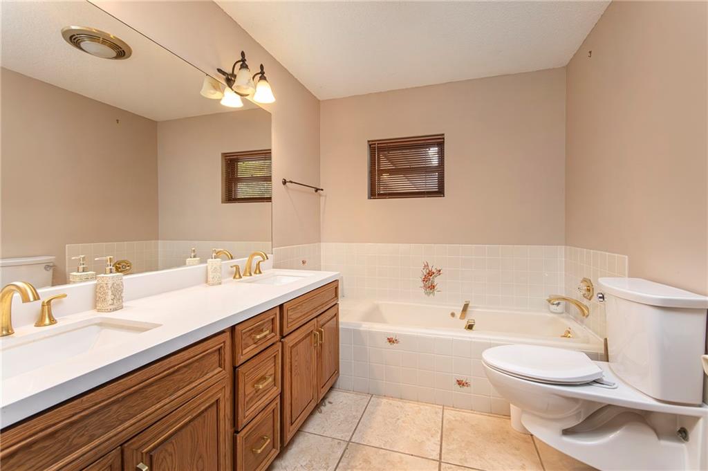 2301 Brooks Road Southeast Dacula, GA 30019 - Photo 51 of 63 a bathroom with a double vanity sink toilet mirror and bathtub