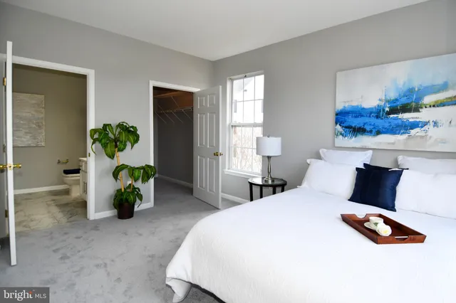 a bedroom with a bed and a potted plant