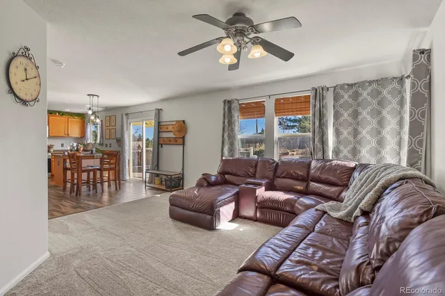 a living room with furniture a dining table and a large window