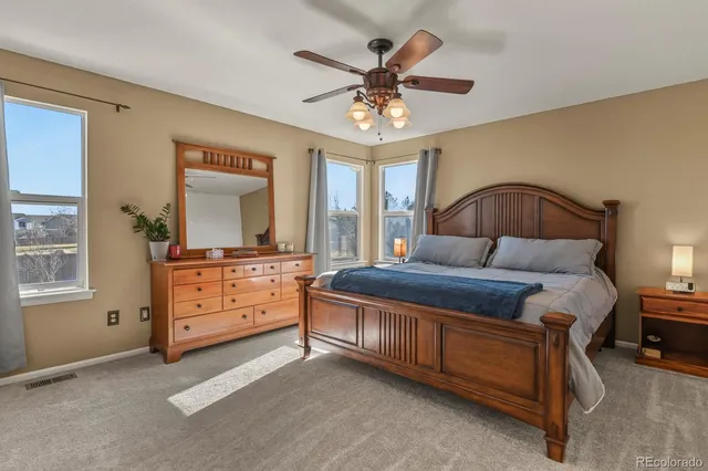 a bedroom with a bed chandelier and dresser