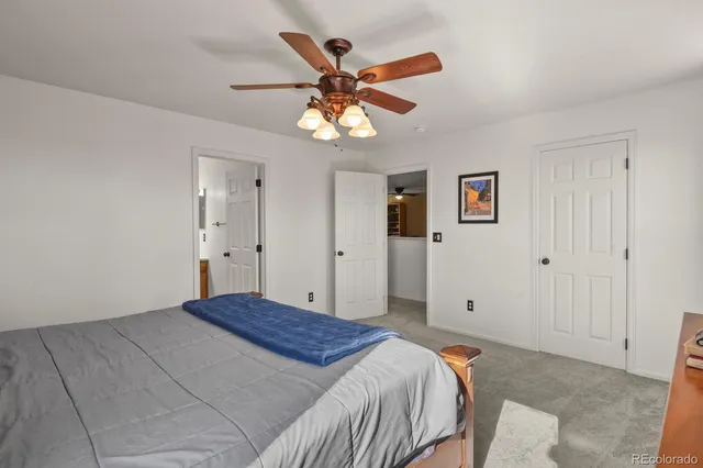 a bedroom with a large bed and a ceiling fan
