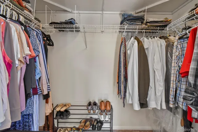 a view of walk in closet with clothes and shoes