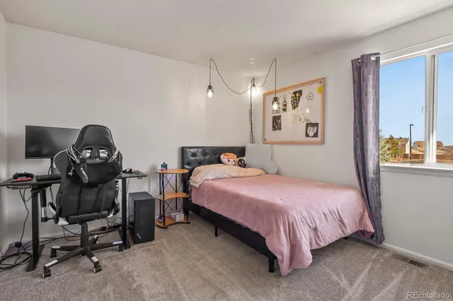 a bedroom with a bed a desk and chair