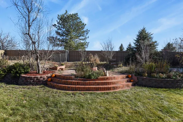 a view of a backyard with plants and a fountain