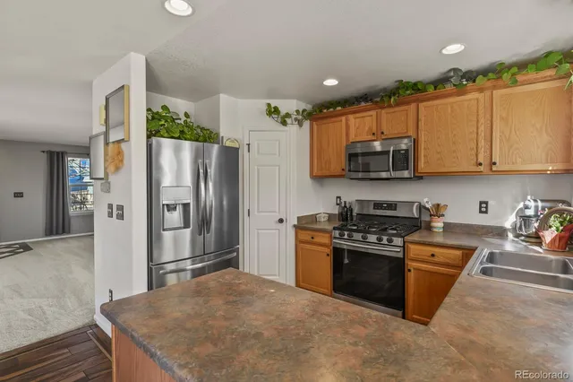 a kitchen with stainless steel appliances granite countertop a stove a refrigerator and a sink