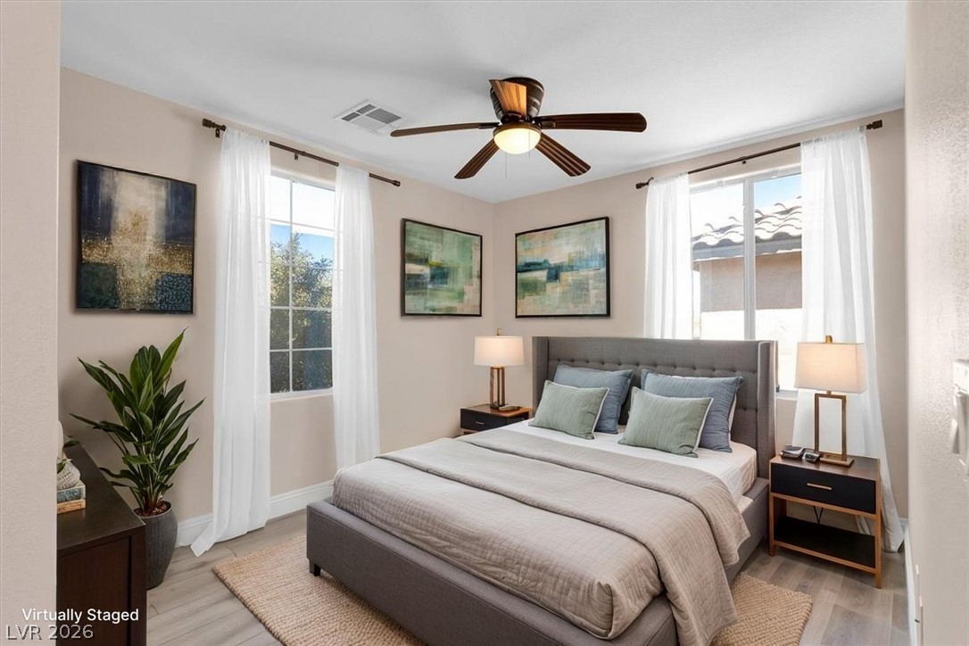 1019 Garnet Ridge Court Las Vegas, NV 89123 - Photo 18 of 34 Bedroom featuring light wood finished floors, a ceiling fan, and multiple windows