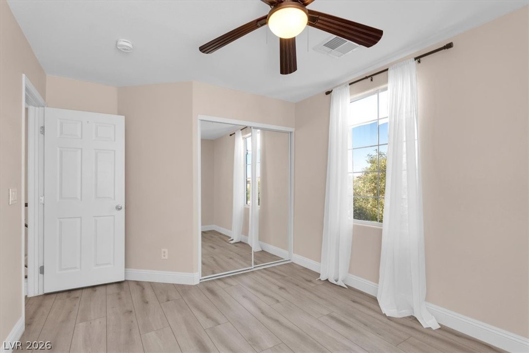 1019 Garnet Ridge Court Las Vegas, NV 89123 - Photo 19 of 34 Unfurnished bedroom featuring light wood-style floors, a ceiling fan, and a closet