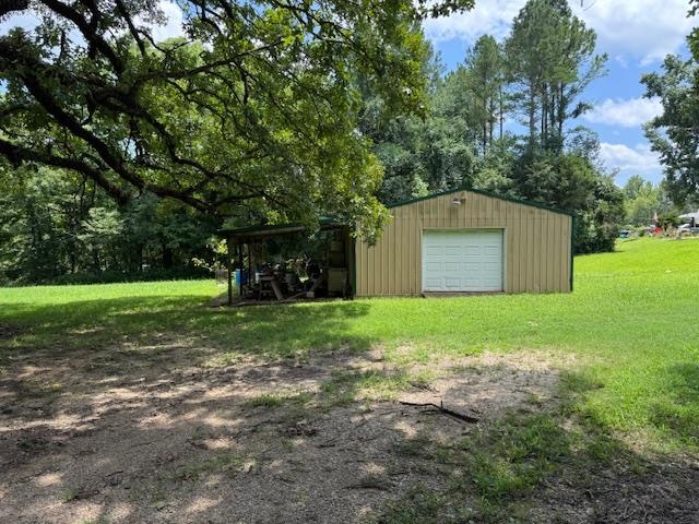 165 Pittman Road Somerville, TN 38068 - Photo 12 of 17 View of grassy yard with an outdoor structure, a garage, and driveway