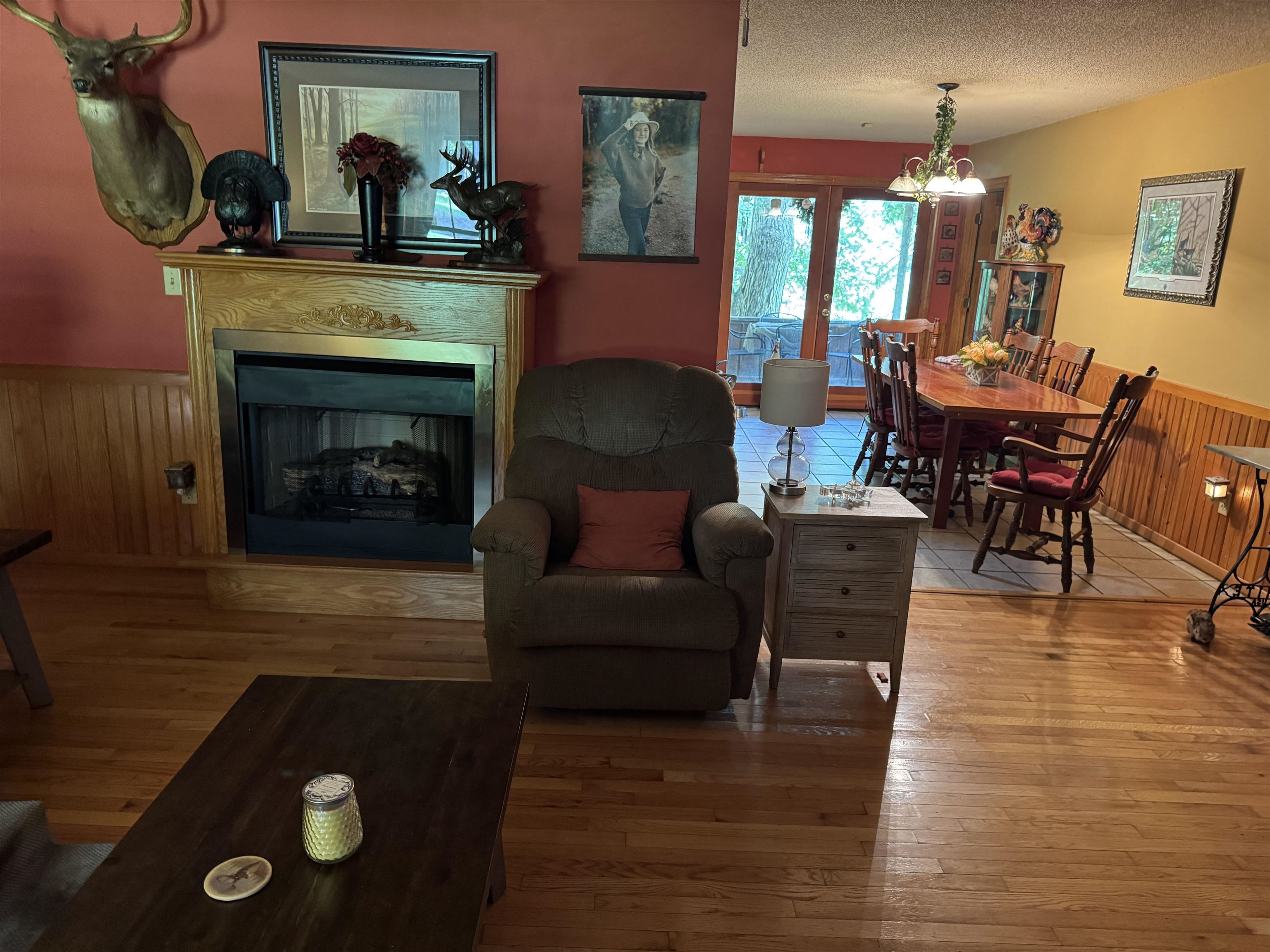 165 Pittman Road Somerville, TN 38068 - Photo 4 of 17 Living area featuring wainscoting, wood-type flooring, a chandelier, wood walls, and a fireplace