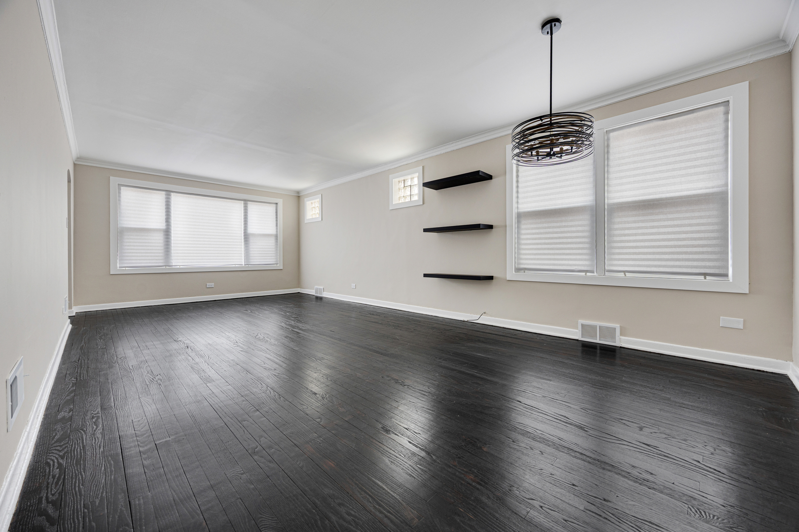 101 West 113th Place Chicago, IL 60628 - Photo 3 of 15 a view of an empty room with wooden floor and a window
