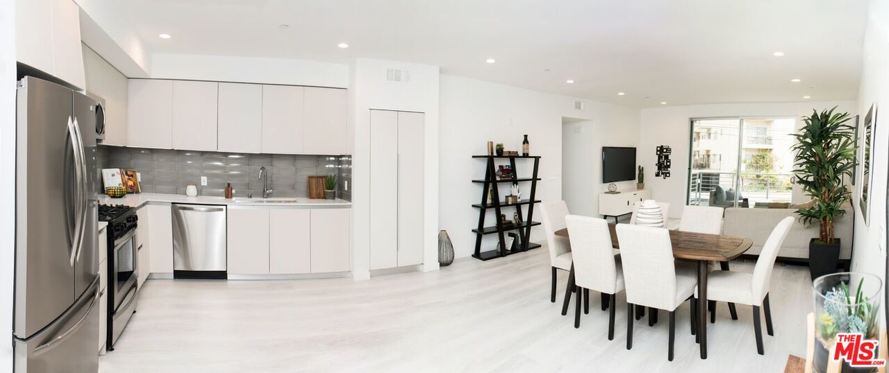 a kitchen with stainless steel appliances kitchen island granite countertop a refrigerator and cabinets