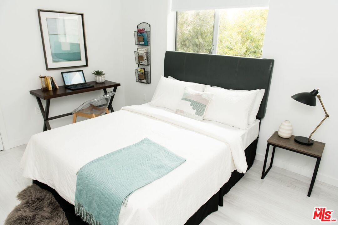 625 South Barrington Avenue, Unit 110 Los Angeles, CA 90049 - Photo 10 of 17 a bedroom with a bed and a window