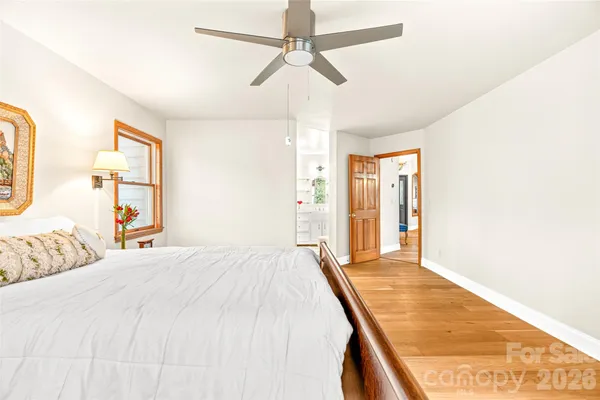 a bedroom with a large bed a chandelier and windows