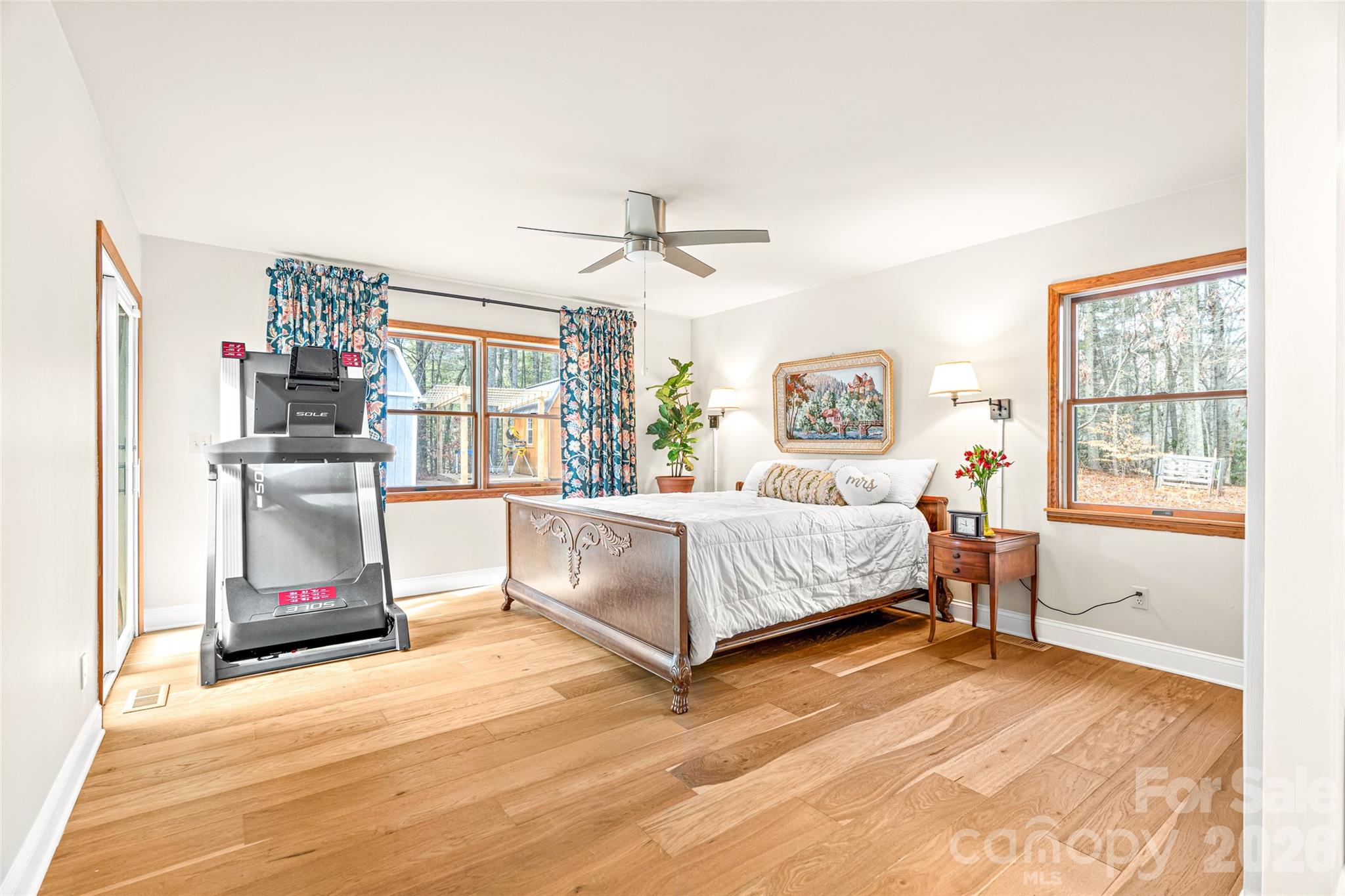 649 Upper Bailey Branch Road Mars Hill, NC 28754 - Photo 19 of 37 a bedroom with a large bed a chandelier and windows