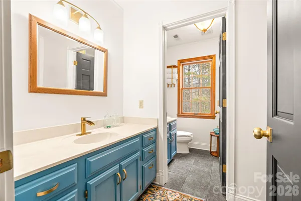 a bathroom with a toilet a sink and a window