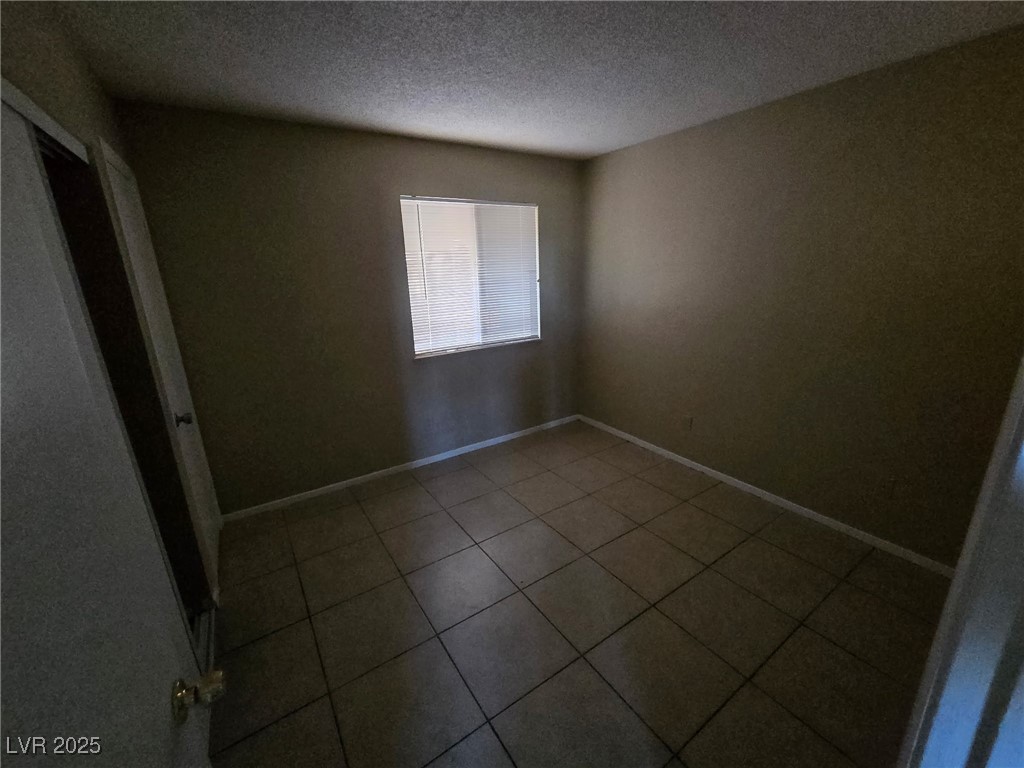 2213 North Jones Boulevard, Unit 2 Las Vegas, NV 89108 - Photo 2 of 3 Empty room featuring a textured ceiling and dark t