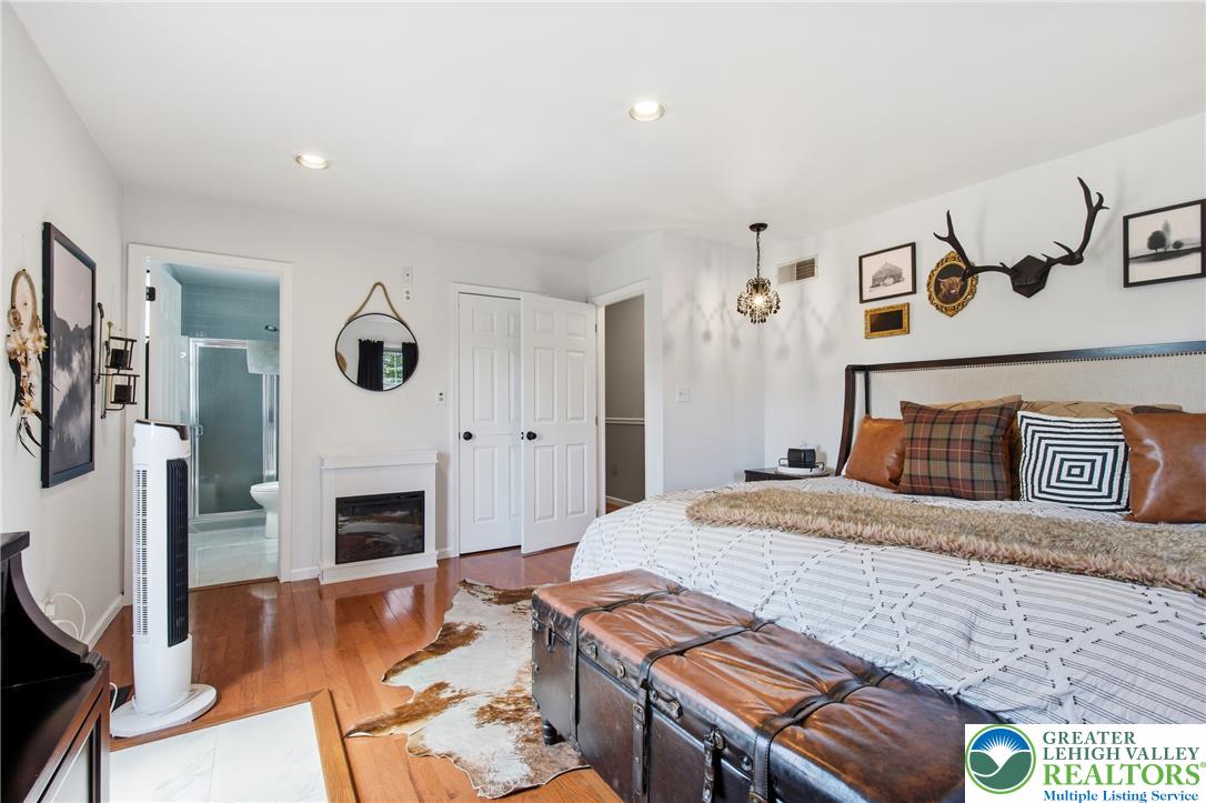 890 Lahr Road Nazareth, PA 18064 - Photo 28 of 71 Hardwood floors and a cozy fireplace define this inviting primary bedroom retreat.
