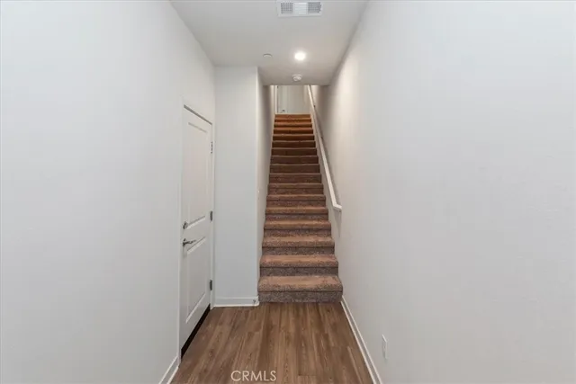 a view of a hallway with wooden floor and entryway